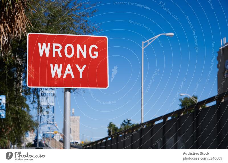 Red and White Wrong Way Road Sign Post Wrong way wrong road sign direction red white city cityscape street urban scene nobody architecture bridge USA Florida