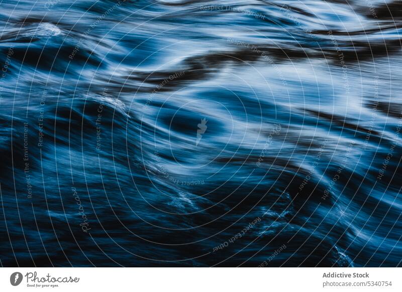 Flowing clear water in motion flow surface ripple blue speed dynamic smooth shine calm slow liquid wavy tranquil clean nature wave splash nobody aqua stream