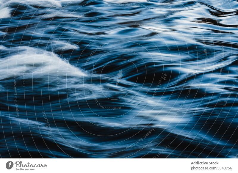 Flowing clear water in motion flow surface ripple blue speed dynamic smooth shine calm slow liquid wavy tranquil clean nature wave splash nobody aqua stream