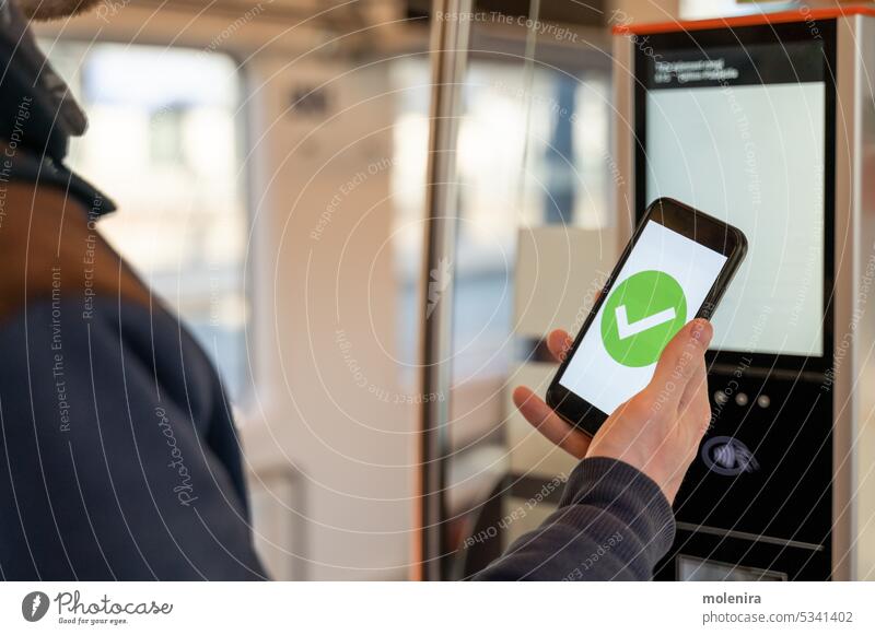 Person buying train ticket with smartphone electronic screen green check mark public transportation tram person hand holding machine purchasing pass checkmark
