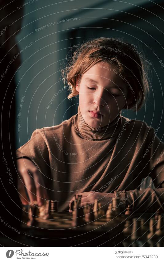 Teenager playing chess teenager child chessboard 12 years old youth game boy player serious caucasian young childhood cute hobby strategic thinking intelligent