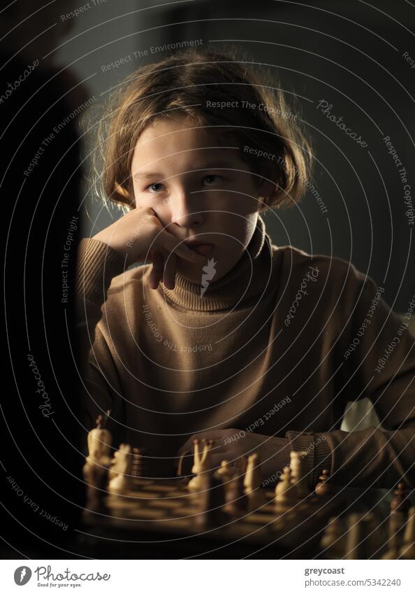 The teenager made a move while playing chess child chessboard 12 years old youth game boy player serious caucasian young childhood cute hobby strategic thinking