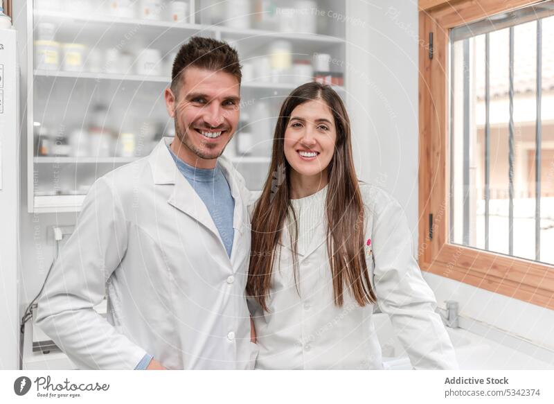 Cheerful medical coworkers looking at camera in drugstore smile pharmacist happy cheerful together positive professional colleague pharmacy medicine young job