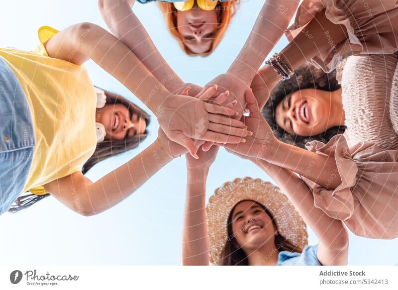 Happy diverse friends stacking hands together group women stack hands smile friendship happy cheerful unity summer team multiethnic multiracial positive gesture