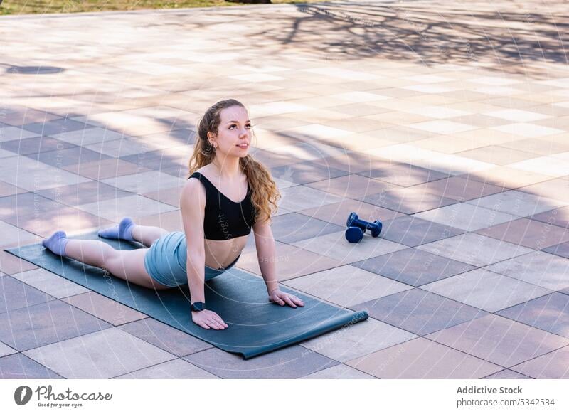 Slim woman doing upward facing dog exercise during yoga - a