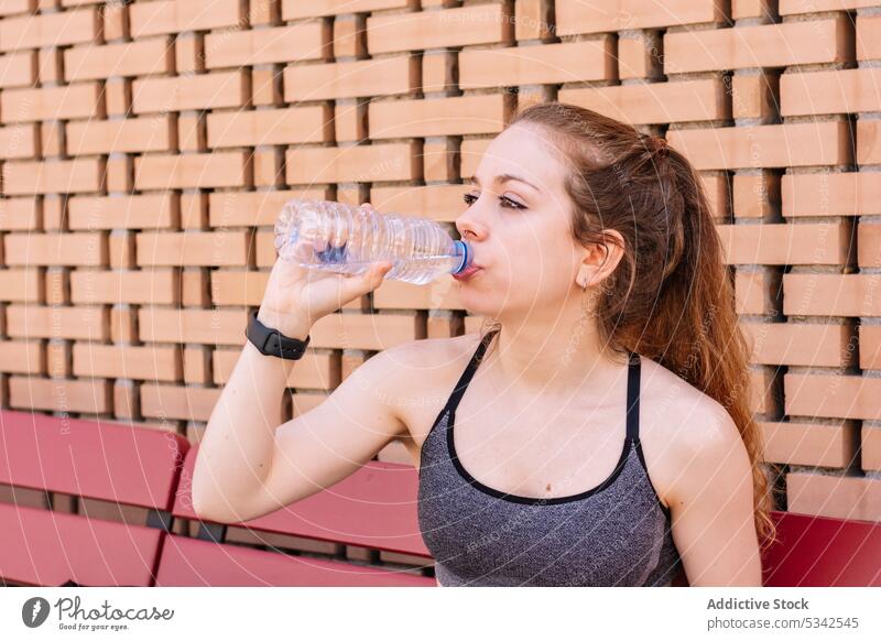 Sportswoman drinking water from bottle after workout sportswoman break hydrate rest training athlete thirst fitness wellness wellbeing healthy female tired gym