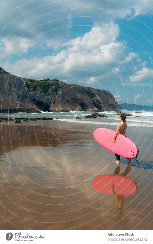 Young woman with surfboard on beach surfer seashore wave activity water holiday sport seaside vacation surfing summer female coast ocean leisure hobby enjoy
