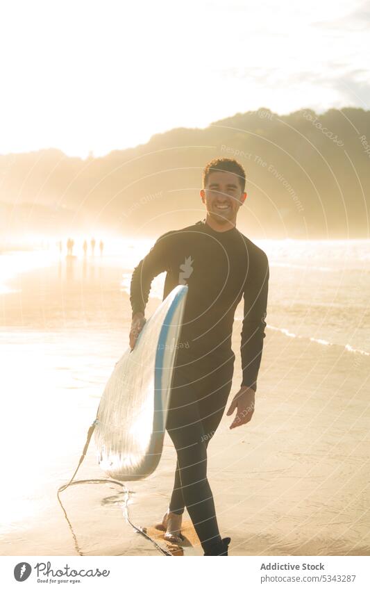 Man walking with surfboard in beach man surfer sea sunset wave sport ocean smile water summer hobby male activity sundown evening coast happy shore active