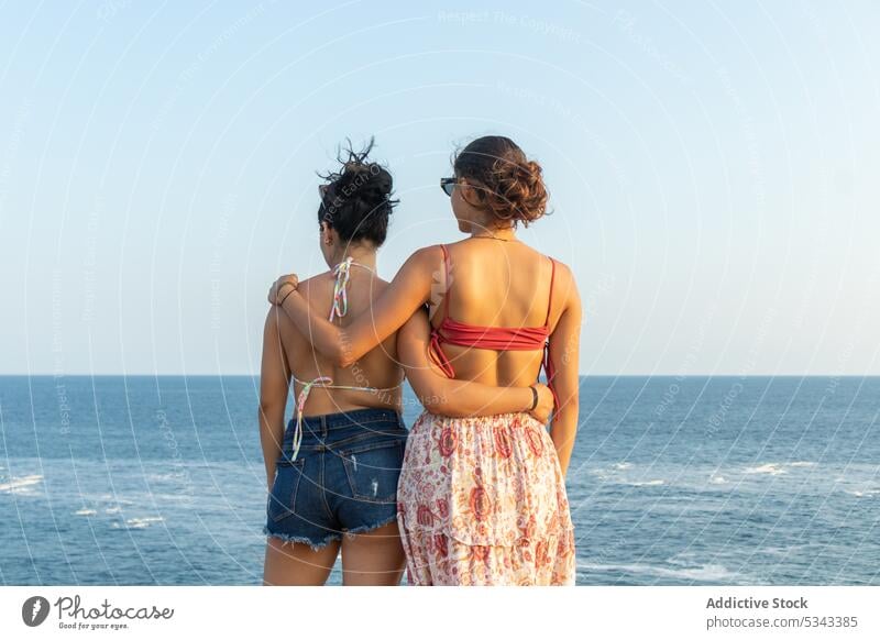 Unrecognizable women hugging against waving sea friend sunset summer vacation coast together wave shore swimwear puerto escondido oaxaca mexico ocean beach rest