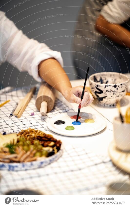 Unrecognizable person painting with palette in workshop artist paintbrush master class draw colorful creative table craft studio hobby design snack skill bright