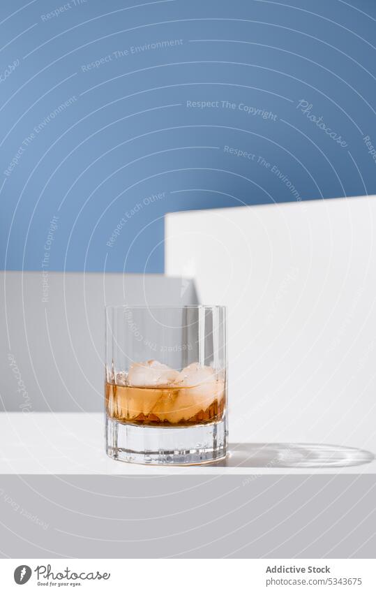 Glass of whiskey with ice glass ice cube alcohol on rocks drink liquid transparent frozen refreshment crystal cold glassware clean taste studio shot isolated