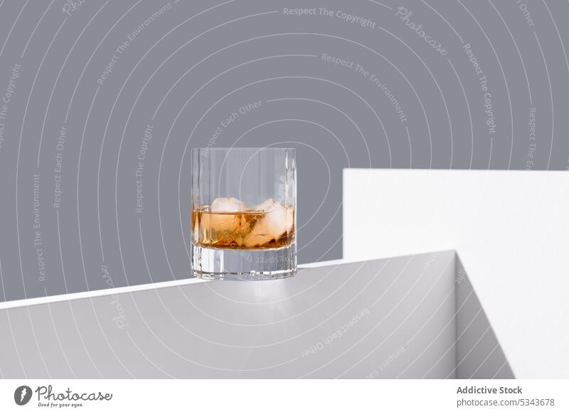 Glass of whiskey with ice glass ice cube alcohol on rocks drink table liquid transparent frozen refreshment crystal edge cold glassware clean taste studio shot