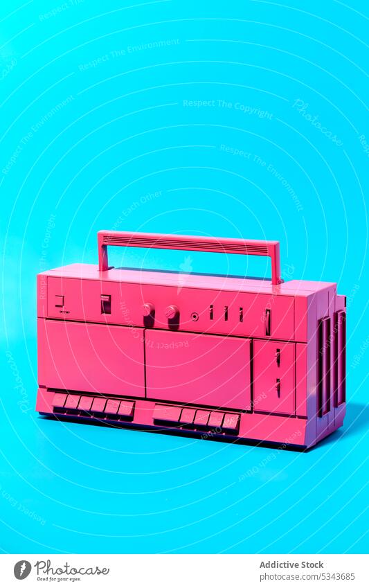 Vintage pink boombox against blue background recorder cassette retro stereo music tape nostalgia sound radio object vintage audio analog song plastic 80s melody
