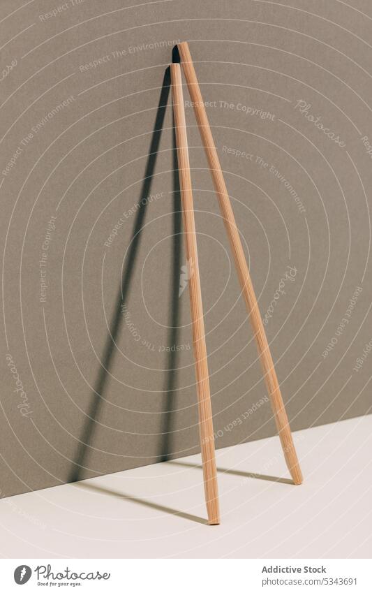 Wooden sticks placed on desk near wall chopstick bamboo tradition simple minimal pair oriental asian material table tool tableware shadow utensil culture
