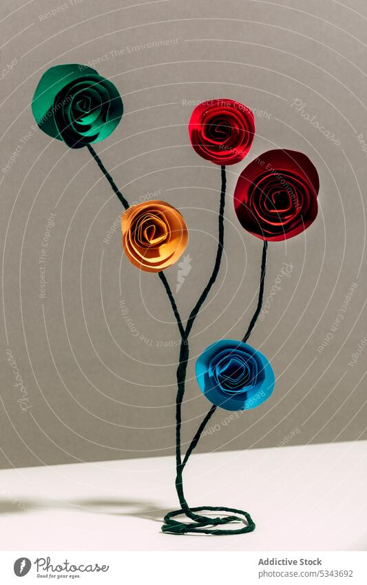 Multicolored paper roses with wire placed on white desk flower decoration creative colorful design art handmade artwork artificial fragile craft bright leaf