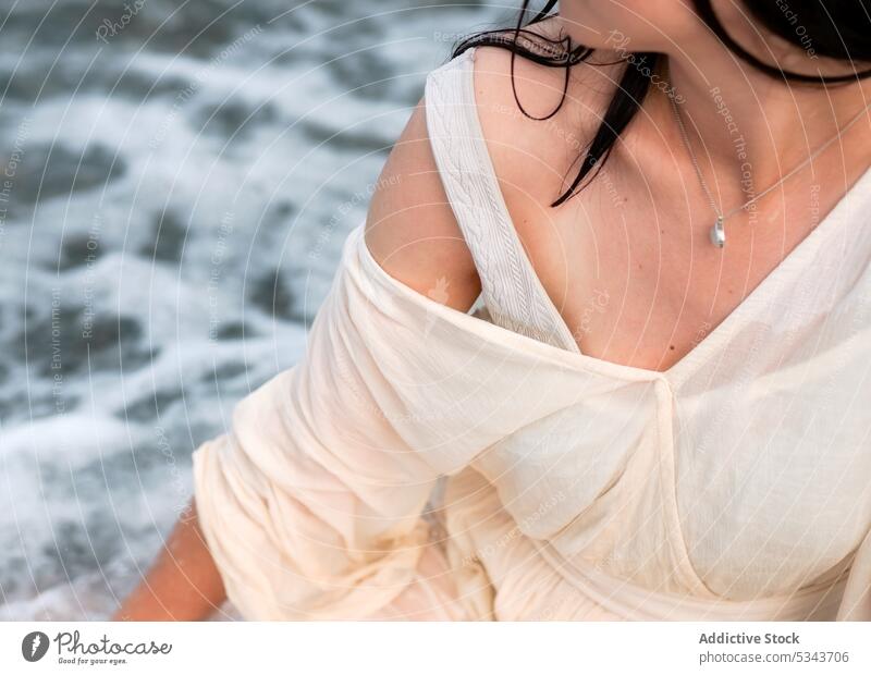 Crop woman in white dress near sea rest beach resort summer vacation relax holiday female coast ocean wave water shore enjoy travel nature necklace harmony