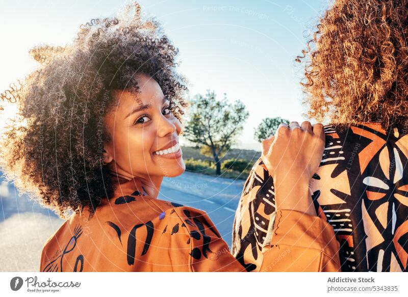 Happy black woman with hand on anonymous friend smile street positive park summer carefree cheerful glad appearance style african american ethnic female happy