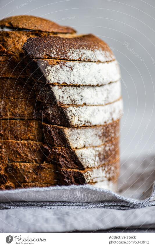 Front view of stack of rye bread slices on grey cloth napkin against blurred light background eat eating food healthy organic plant based sour dough textile