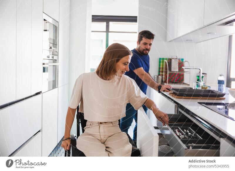 Positive young couple preparing to cook in kitchen family wife husband rehab disabled wheelchair happy together relationship bonding love at home adorable