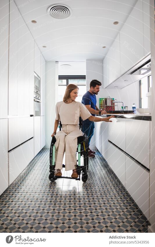 Happy couple having fun in kitchen together happy disabled rehab cook prepare cheerful home husband wife relationship discuss wheelchair meal love healthy food