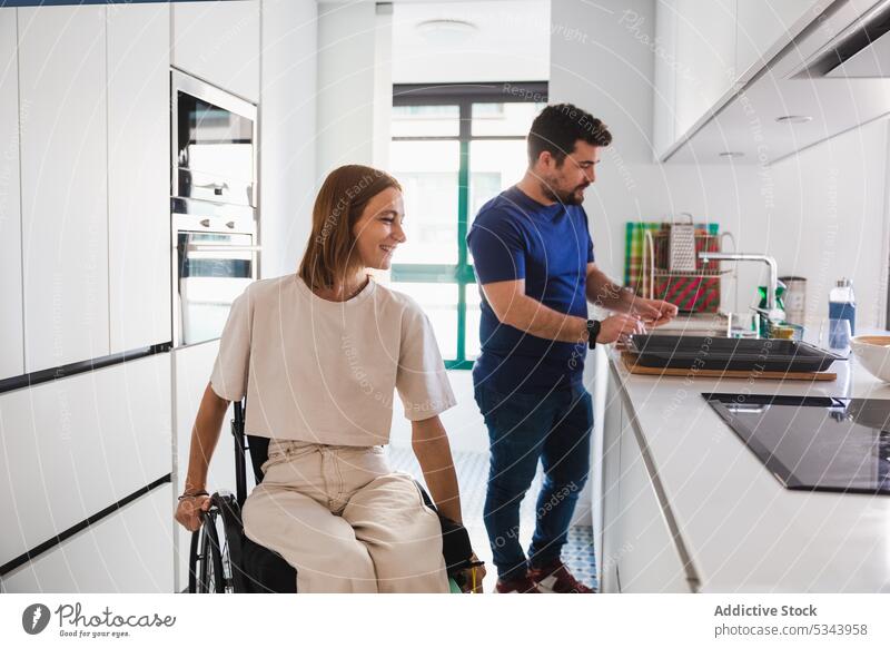 Happy couple having fun in kitchen together happy disabled rehab cook prepare cheerful home husband wife relationship discuss wheelchair meal love healthy food