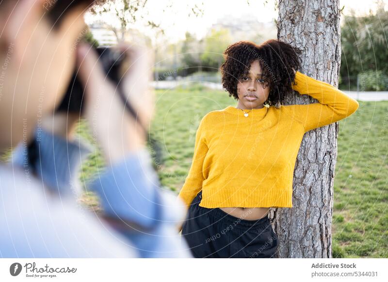 Black woman standing near tree for photo shooting photo camera photographer take photo photography moment park nature memory summer young male lawn ethnic black