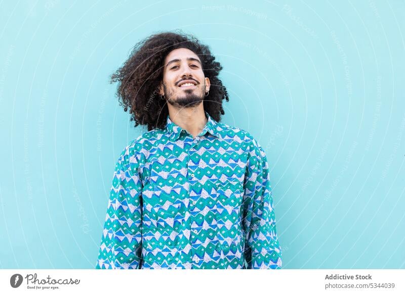 Cheerful black man with curly hair trendy earring beard afro style model individuality portrait hairstyle ethnic male african american color fashion confident