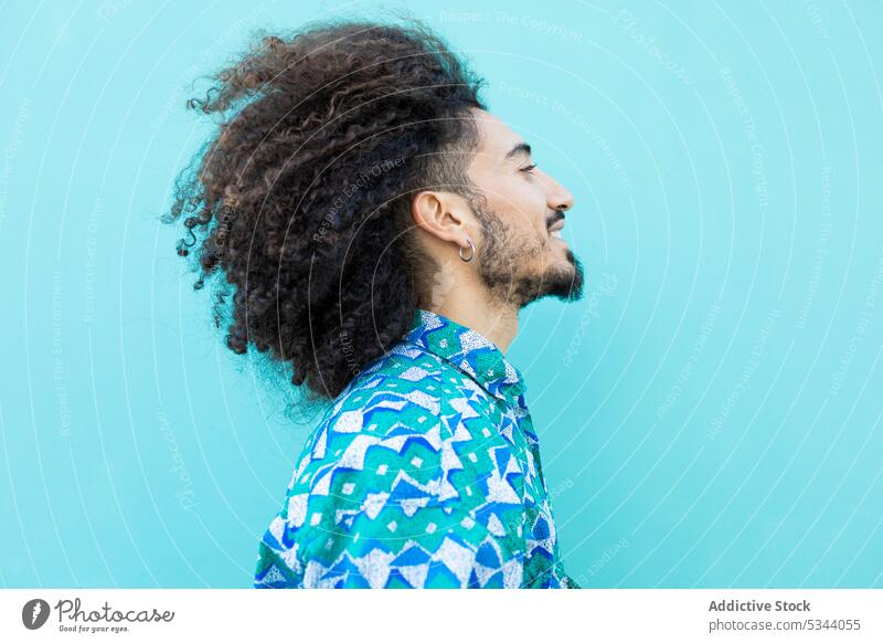 Side view of cheerful black man with curly hair trendy earring beard afro style model individuality hairstyle ethnic male african american color fashion happy