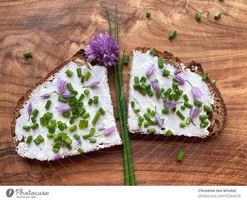 A slice of bread with cream cheese, chive rolls and chive flowers lies on a wooden board Bread Slice of bread Sandwich Appetite Dinner Breakfast Nutrition