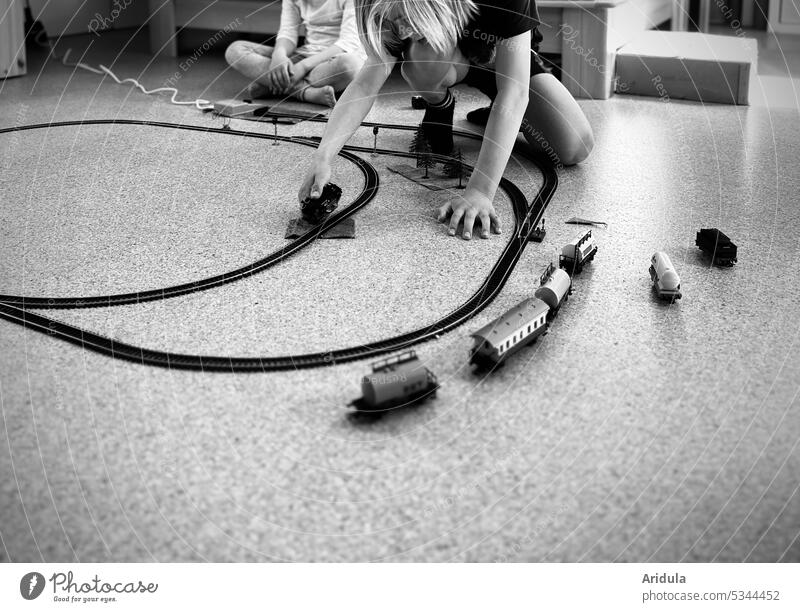 Children playing with model train b/w Model railroad loc wagon Toys children rails Infancy Playing floor Track Train Childhood memory
