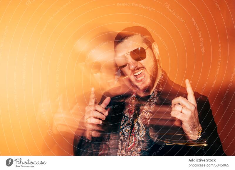 Delighted man pointing up in sunglasses in studio point up hipster excited trendy style gesture happy show cheerful male beard mouth opened amazed demonstrate