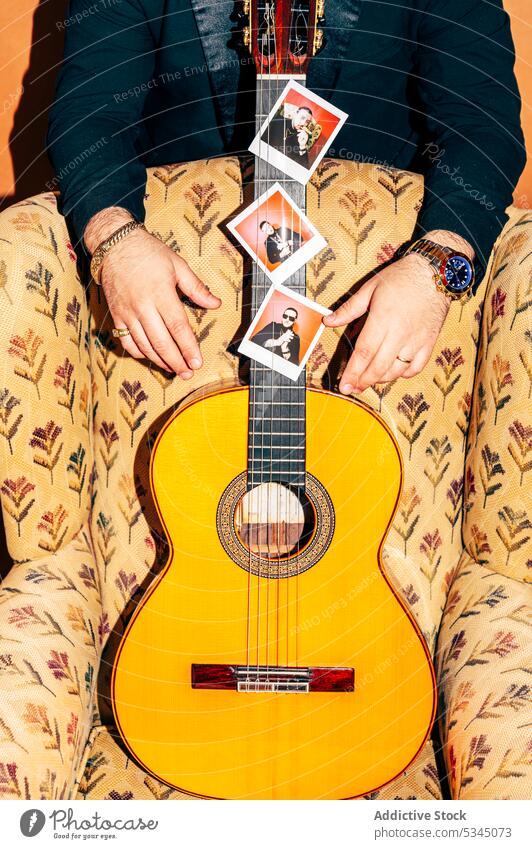 Unrecognizable man near acoustic guitar on armchair studio guitarist musician photo talent string hobby male instrument melody sound tune chord equipment
