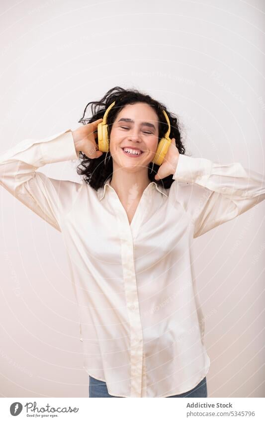 Happy woman in headphones listening to music happy headset portrait gadget cheerful smile eyes closed wireless device sound female song young audio melody