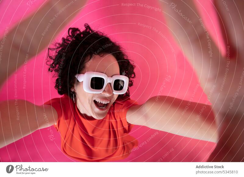 Funny stylish woman showing palms over pink background frame gesture style sunglasses smile happy sign cheerful elegant positive symbol optimist young female