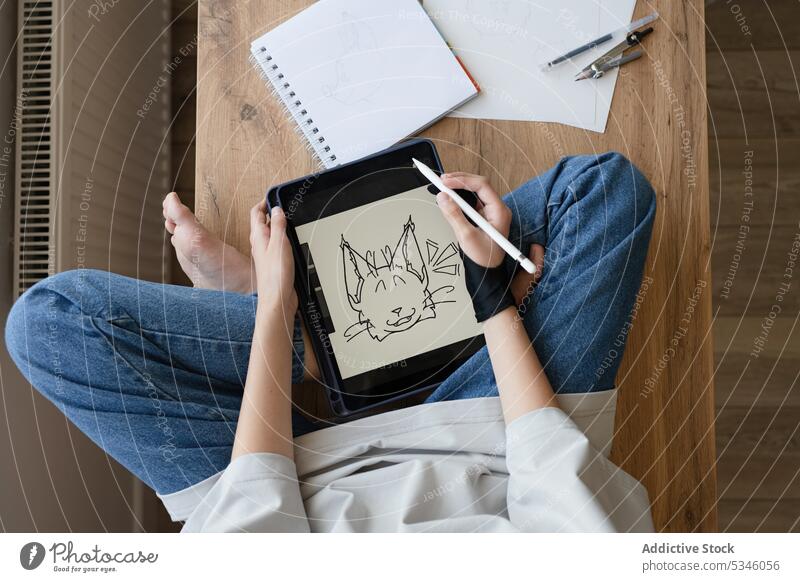 Crop anonymous girl drawing animal on tablet sitting on table artist creative sketch electronic digital screen teenage stylus using modern inspiration