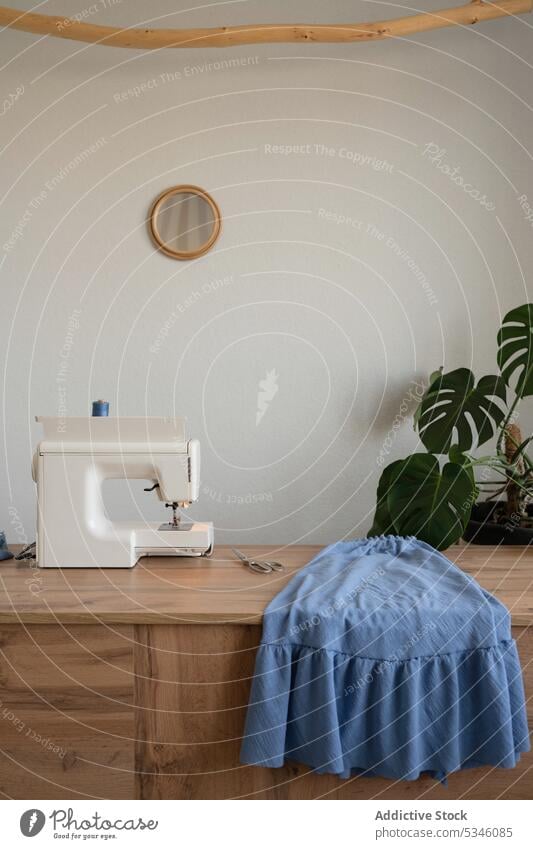 Modern sewing machine and cloth on table atelier fabric design industry material manufacture workshop thread craft modern contemporary creative equipment studio