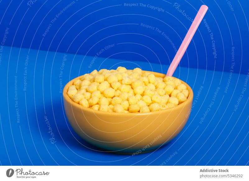 Generative AI illustration of bowl with cereals and plastic spoon placed on blue background zero waste concept flake food breakfast grain meal nutrition snack