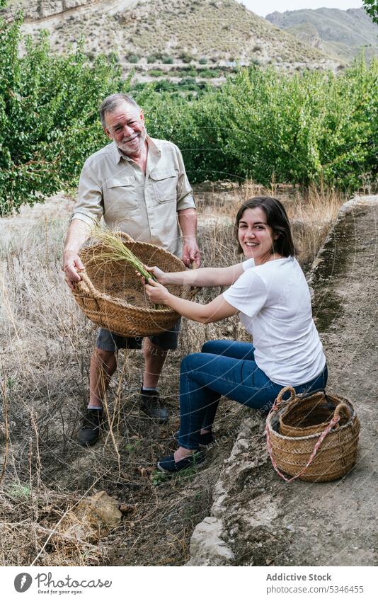 Happy woman with father collecting halfah grass for natural fiber crafts esparto farmer smile family business harvest gardener prepare daughter small business