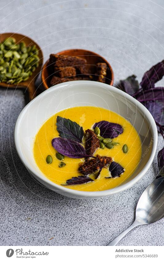 Bowl with pumpkin cream soup with basil herbs on table bowl colorful creamy crusty detox diet dinner dinnerware eat food fresh healthy keto lunch meal organic