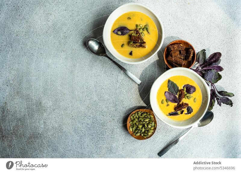 Bowls with pumpkin cream soup with basil herbs on table bowl colorful creamy crusty detox diet dinner dinnerware eat food fresh healthy keto lunch meal organic