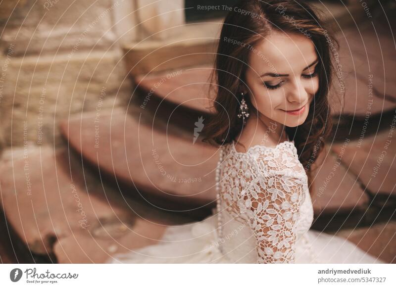 portrait of a beautiful young bride in a white wedding dress with long hair in the old European city. Woman near old building. wedding day girl town woman