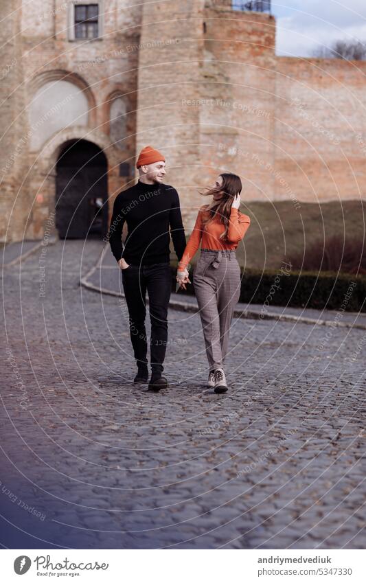 Love story of the beautiful young man and woman walking on the open air the city. embrace on a city walk. copy space. loving couple walking in the city in the open air