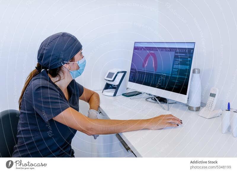 Female doctor working on computer in office dentist woman clinic dental using mask professional stomatology chair modern device monitor hospital medicine female