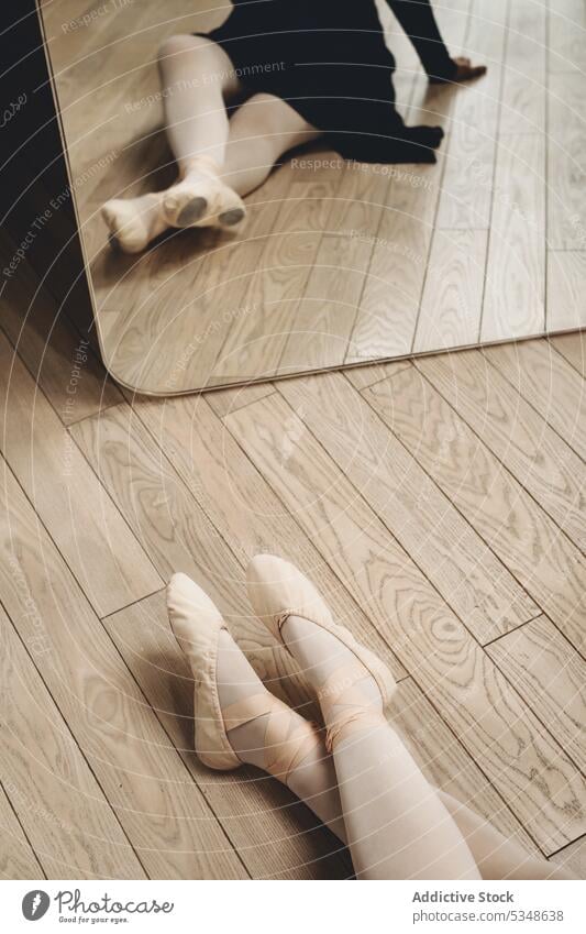 Anonymous ballerina in pointe shoes on floor woman studio ballet dancer rehearsal choreography mirror grace classic sit practice rest talent lesson elegant