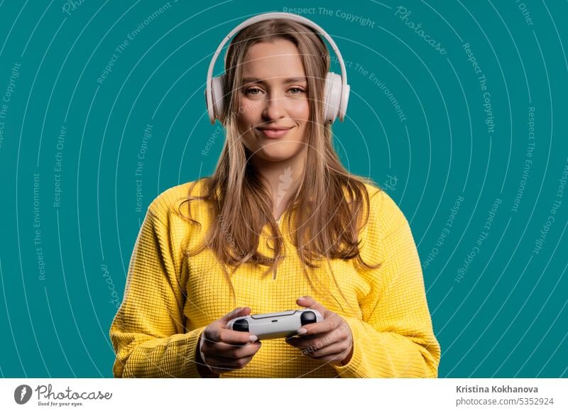 Young woman playing online video game, console TV with joystick on blue backdrop arrow button closeup computer control controller electronic enjoy entertainment
