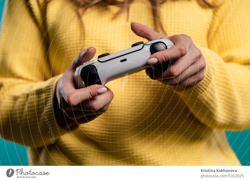 Hands of teenager girl playing online video game, console TV with joystick arrow button closeup computer control controller electronic enjoy entertainment