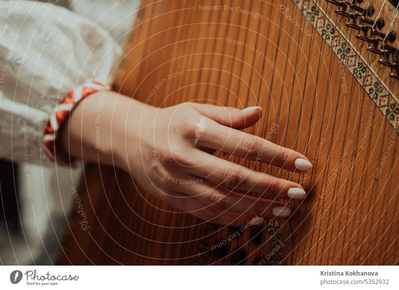 Woman playing on ethnic traditional ukrainian instrument bandura or pandora acoustic art bandurist classic classical closeup concert culture embroidered
