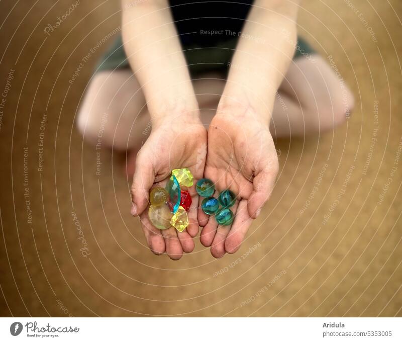 Child with small colorful treasures in hands No. 2 Infancy Treasure treasure hunt Find search dig Dig Hide Legs frowzy Pride Marbles Playing variegated Indicate