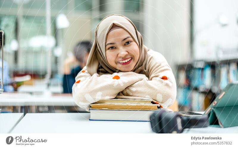 Portrait of asian muslim female student in a library real people teenager campus positive exam knowledge confident academic adult lifestyle academy adolescent