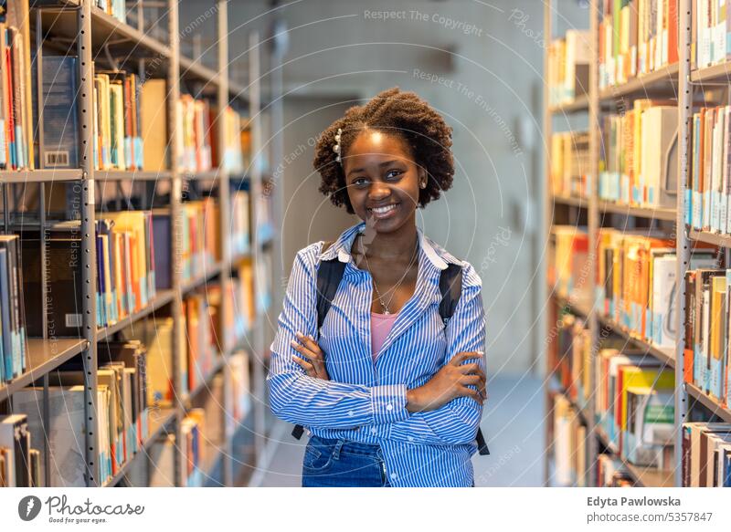 Portrait of black female student standing in a library real people teenager campus positive exam knowledge confident academic adult lifestyle academy adolescent